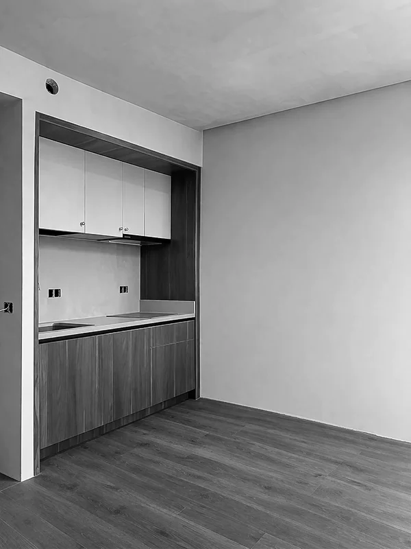 Private apartment renovation in Batumi with newly installed compact built-in kitchen and dark wood flooring