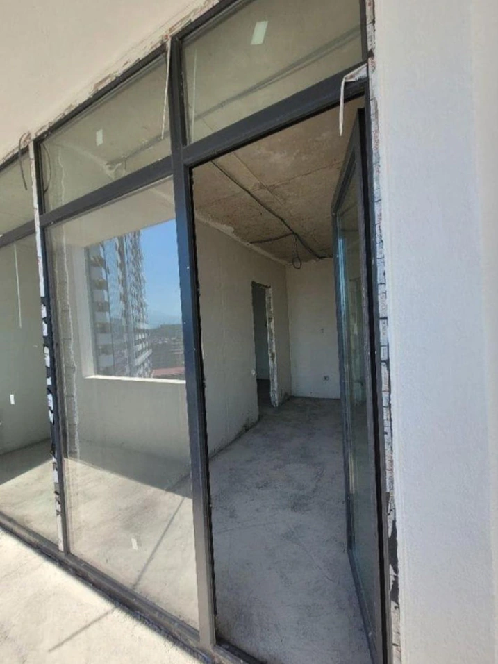 Panoramic balcony glazing and open terrace door in a white-frame Accent apartment