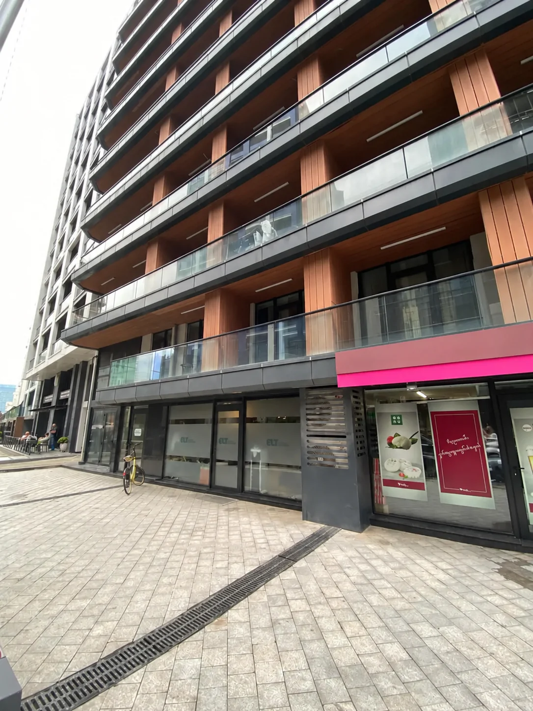 Optima facade in ELT Quarter, Batumi, with glass balconies and ground-floor shops