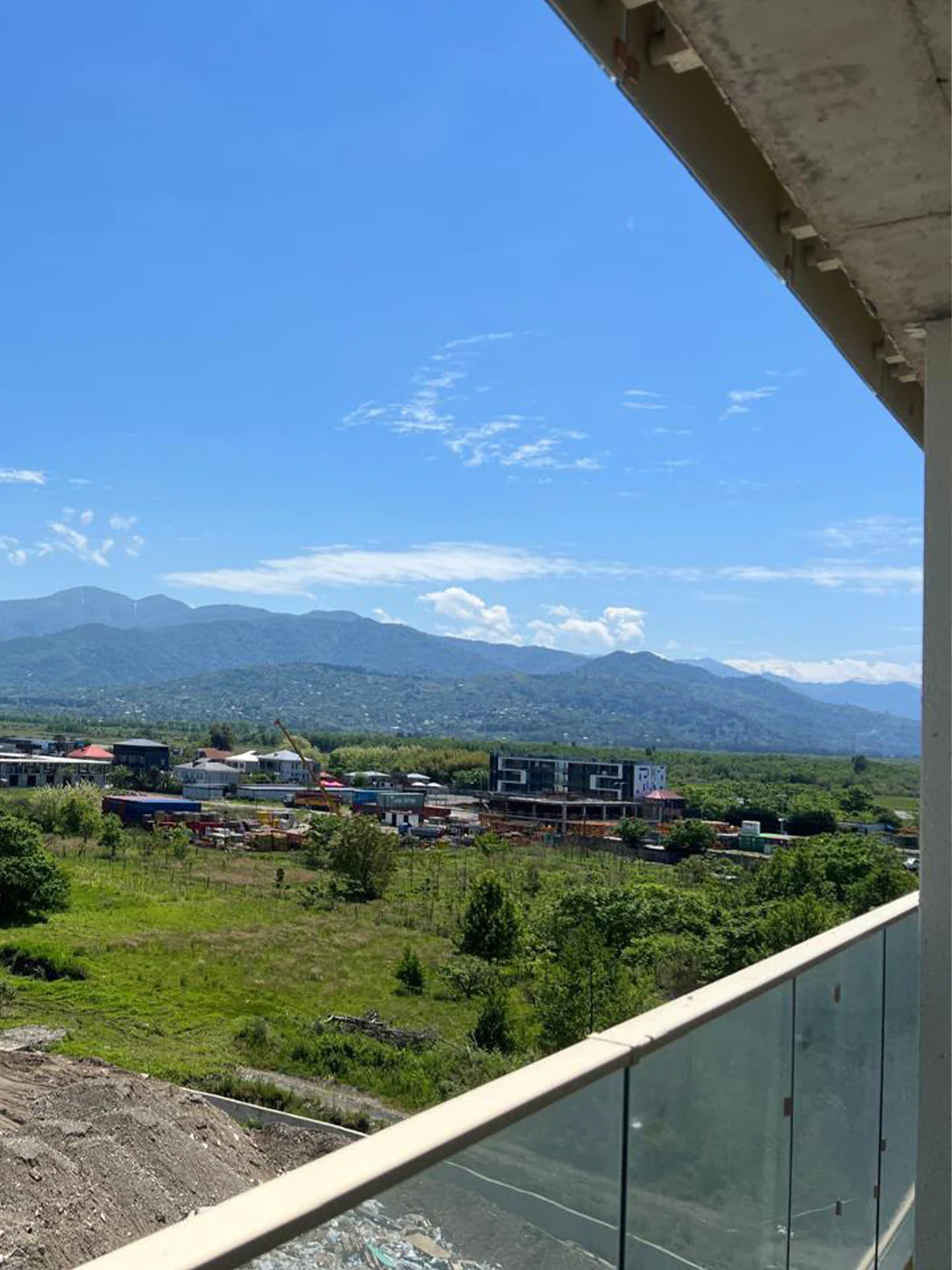 Mountain views from the apartment balcony, overlooking greenery and nearby buildings