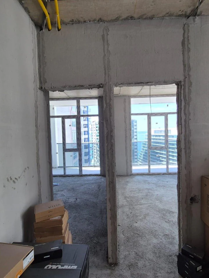 Unfinished two-bedroom apartment interior with balcony windows
