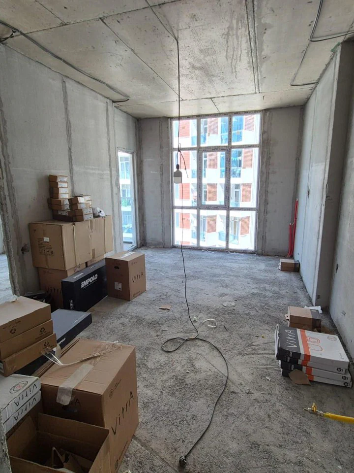 Unfinished living area with large floor-to-ceiling window