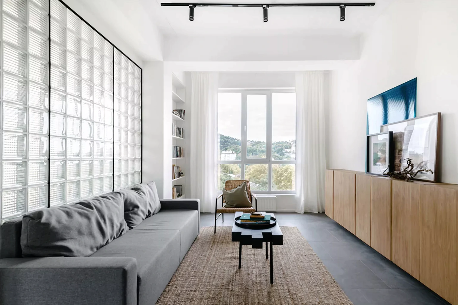 Bright living room with panoramic window and glass-block wall